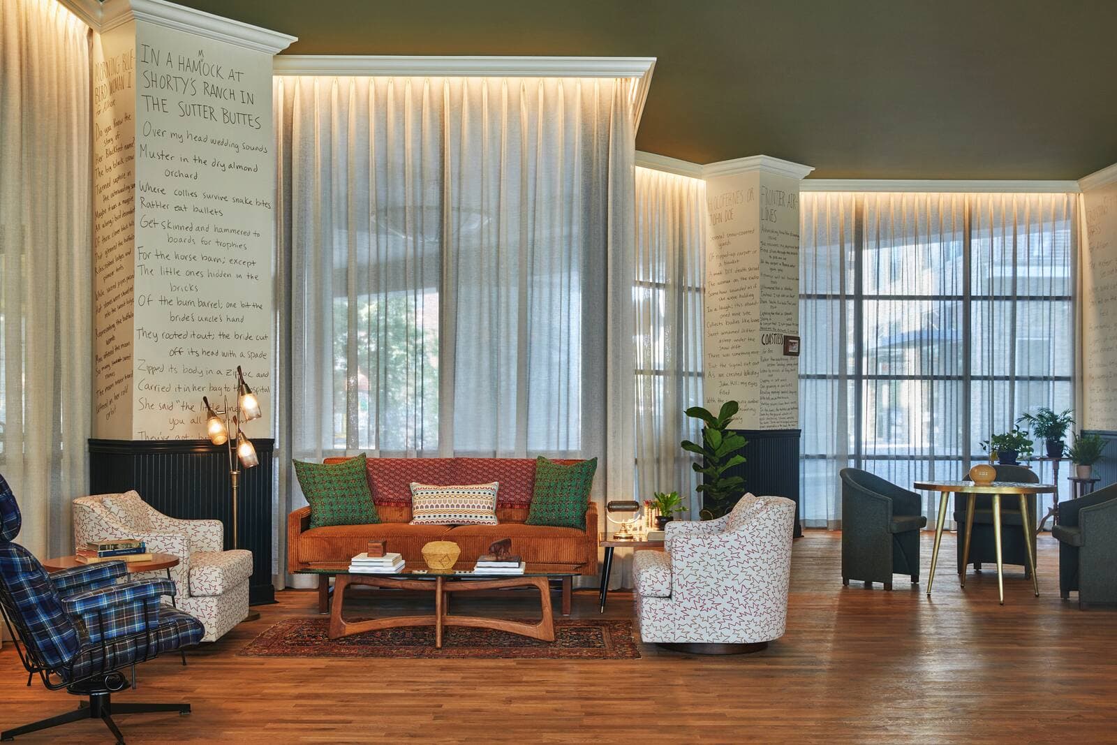 A lobby lounge with poem-covered walls and tall downtown windows